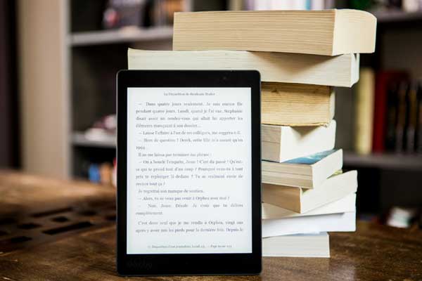 Stack of Books on a table with a tablet standing against the books
