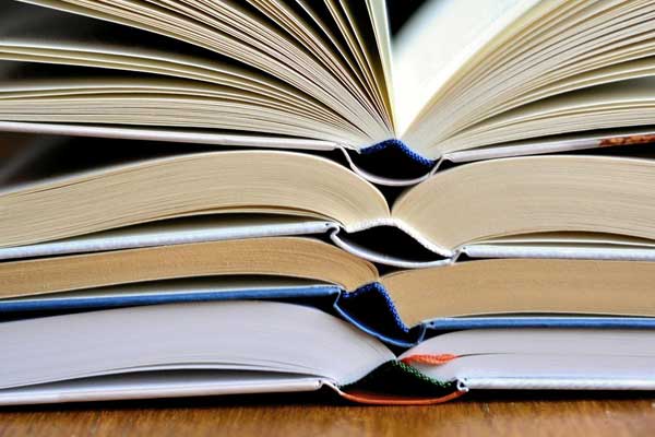 stack of open books on a wood table