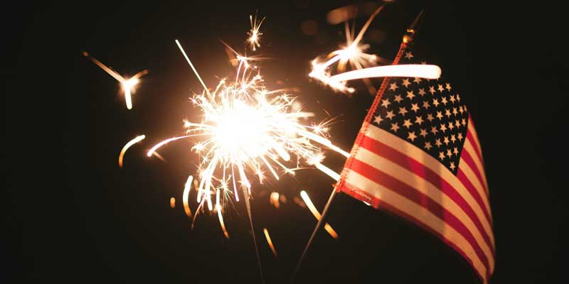 Sparkler at Night Near a Small American Flag