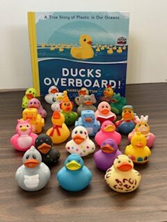 Ducks Overboard book with 24 multi-colored ducks in front of book.