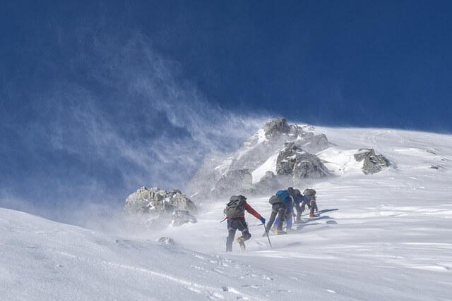 Three mountain climbers in the snow.