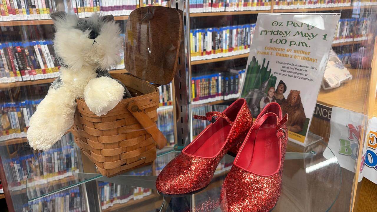 shoes Red Dorothy shoes and basket with stuffed dog inside a display cabinet