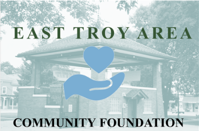 East Troy Area Community Foundation Logo in light blue (hand with heart above it) superimposed on picture of Village Square gazebo.